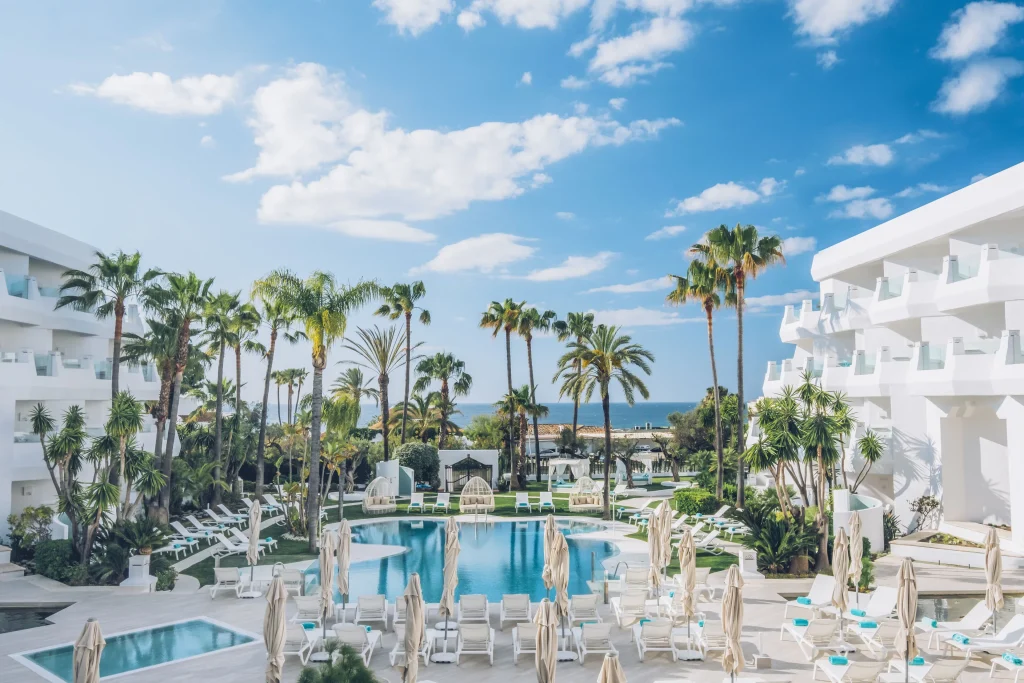 Family-friendly luxury beach resort with spacious swimming pool, kids splash pool, and palm trees in Marbella