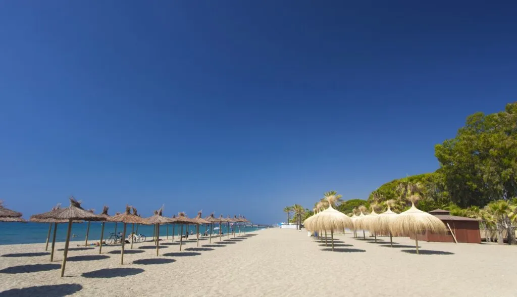Playa de Nagueles on the Golden Mile with wooden sunset pier and Mediterranean water