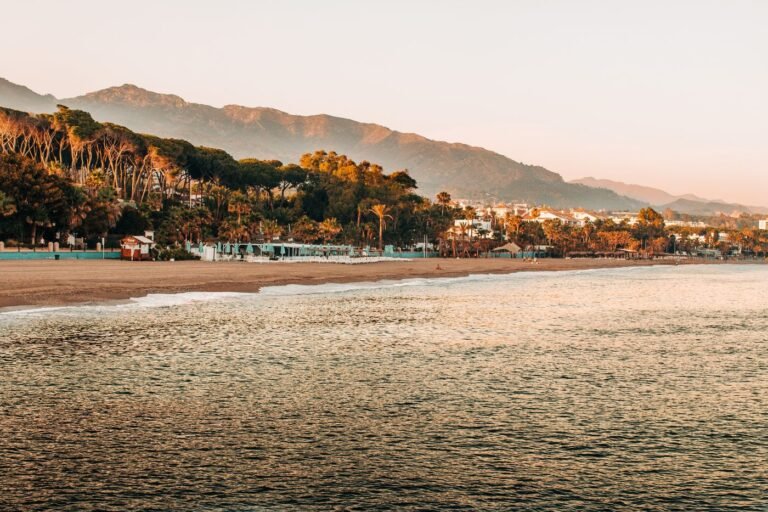 Sunrise over a quiet Marbella beach with mountains behind