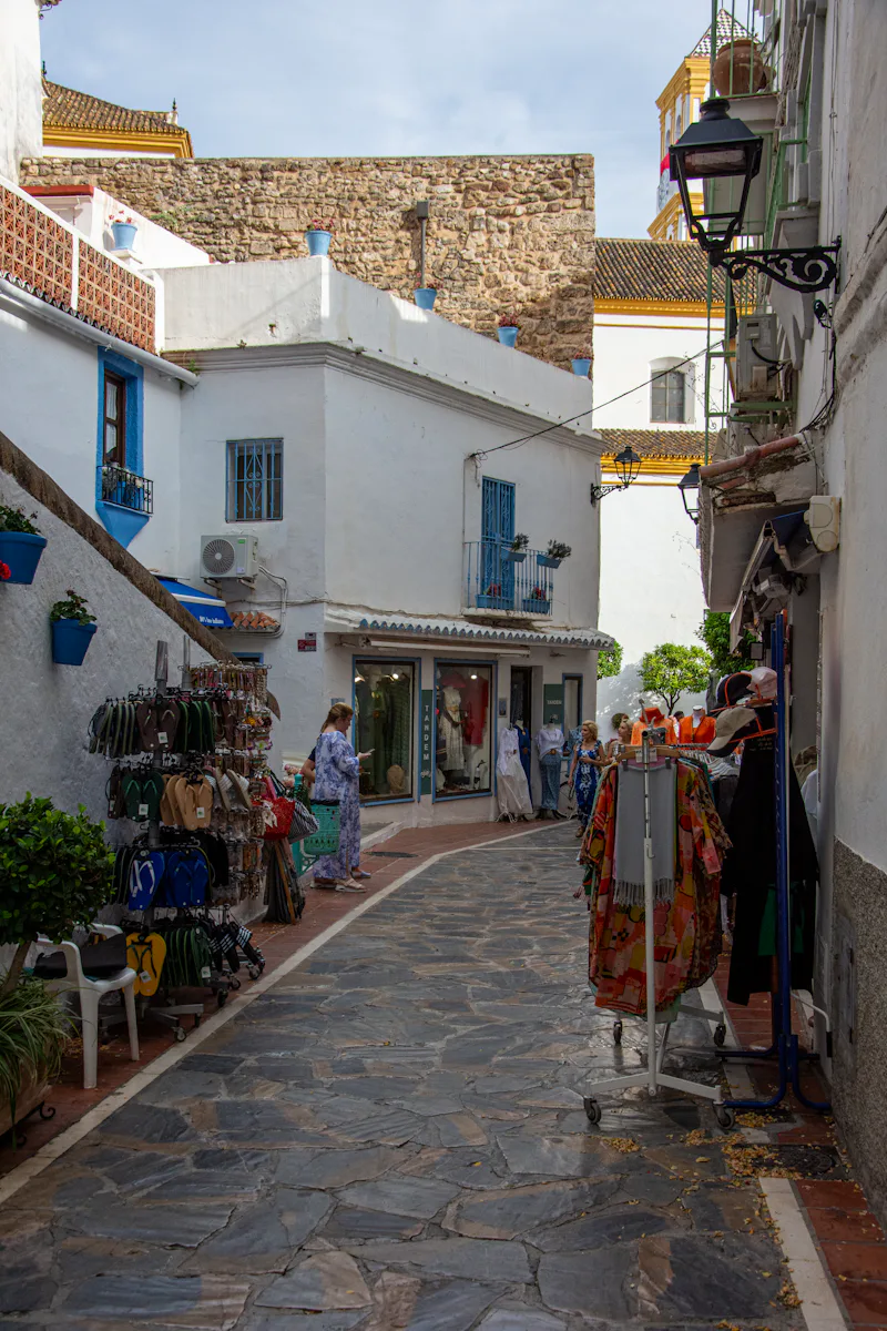 Cobblestone street with white buildings and boutique shops in Marbella Old Town
