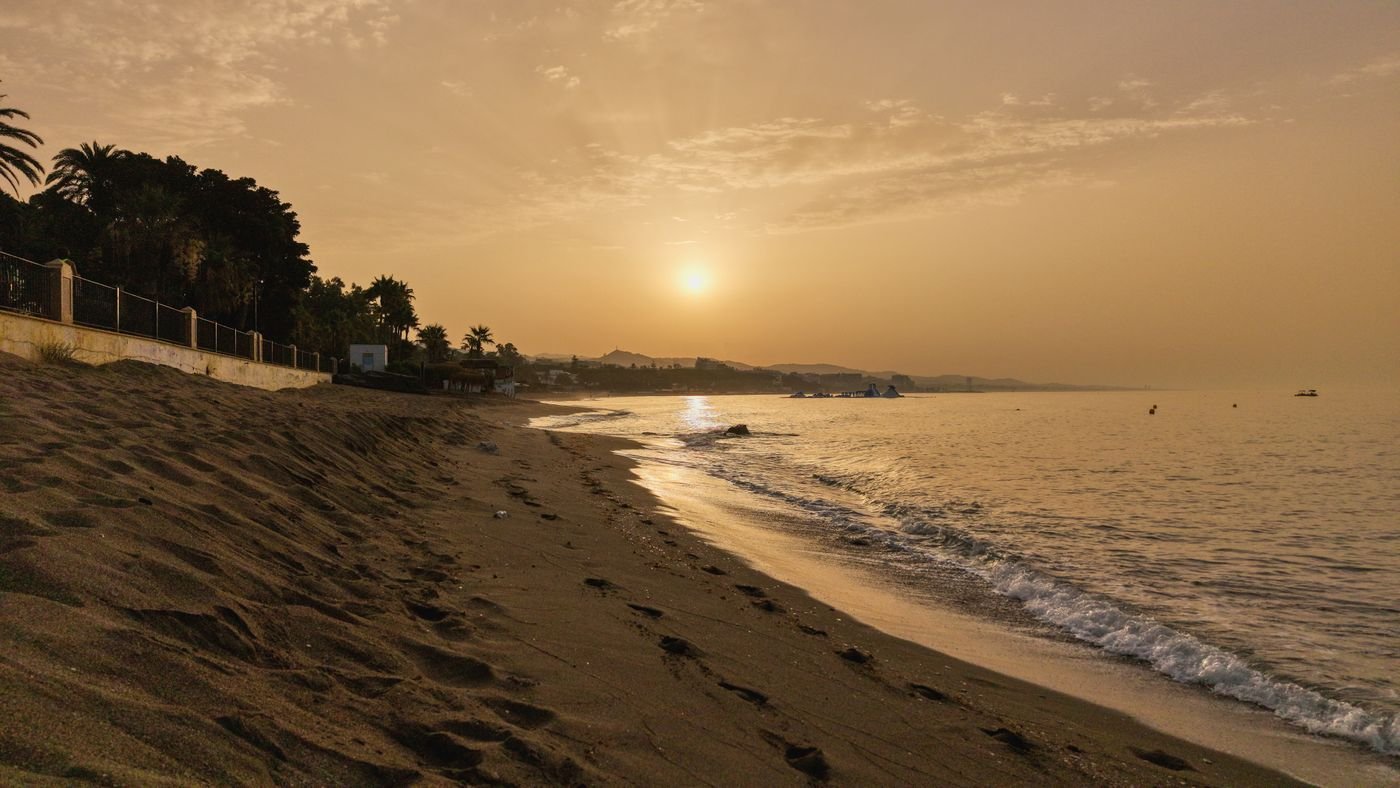 Sunset over Marbella's sandy coastline