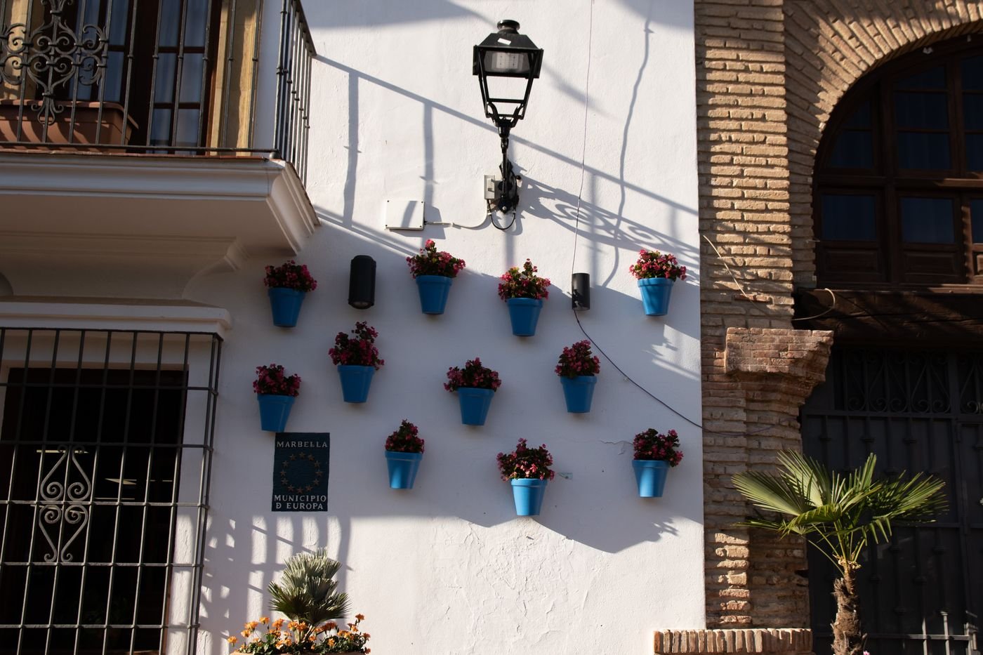 Flowers in blue pots on a whitewashed wall in Marbella Old Town