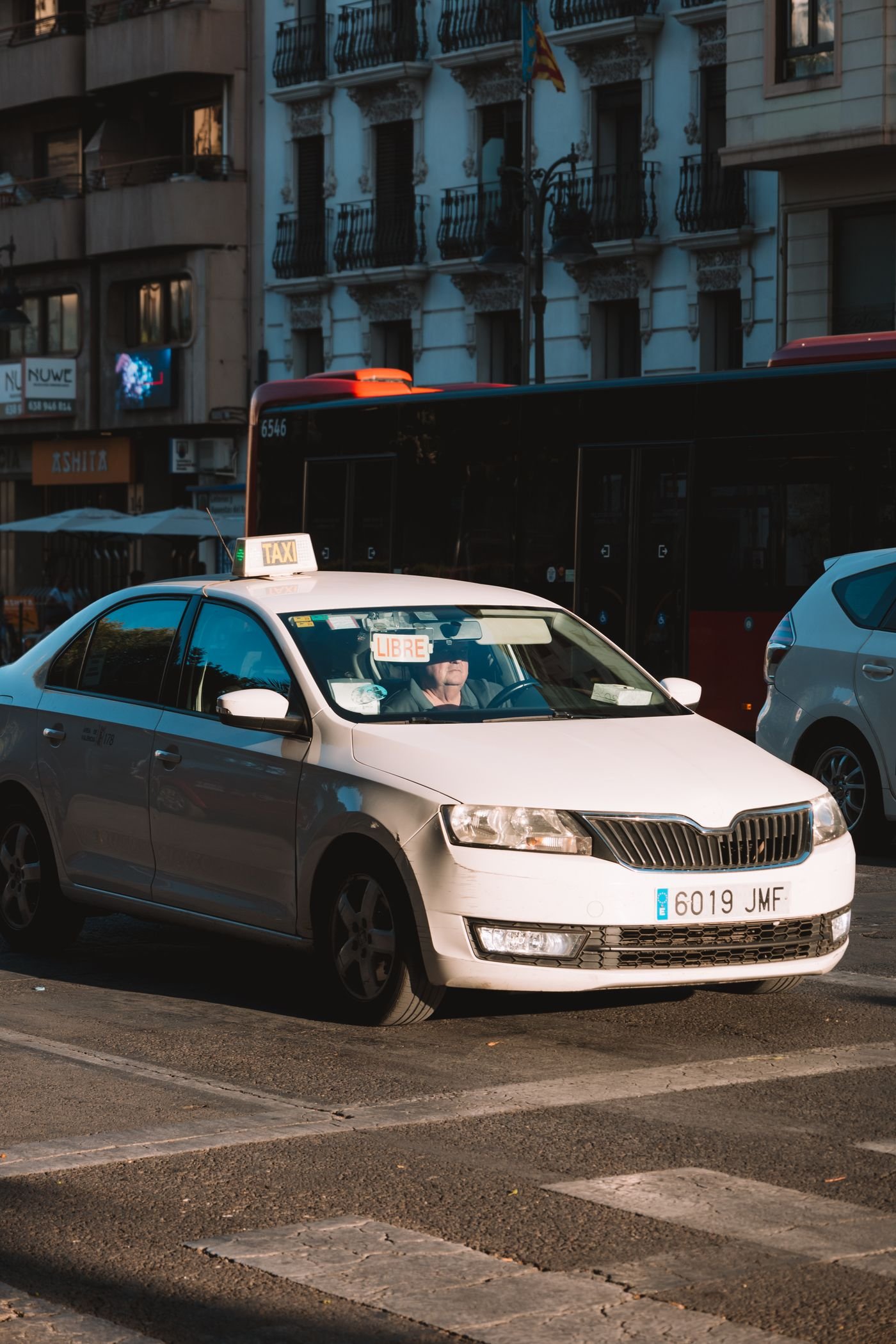 White taxi on a city street in Spain