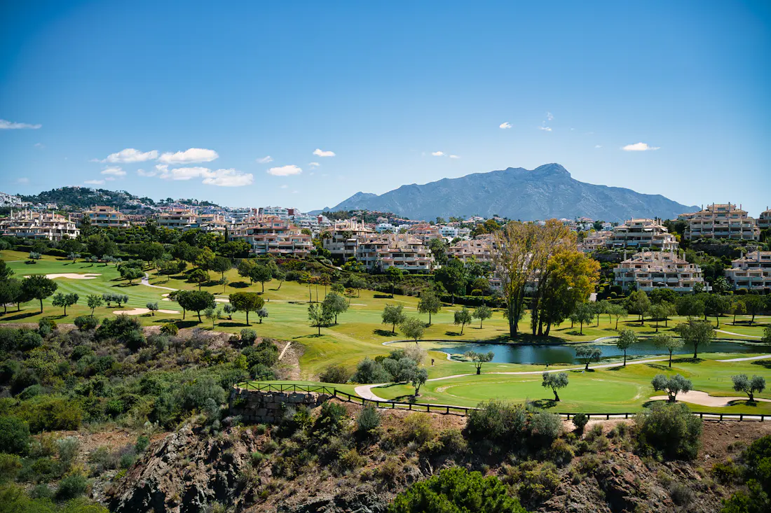 Golf course fairway and lake with mountains behind in Marbella