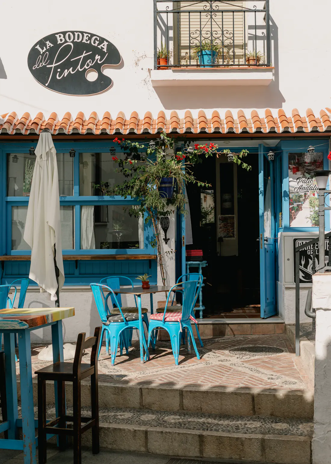Restaurant terrace with blue tables and chairs in Mijas